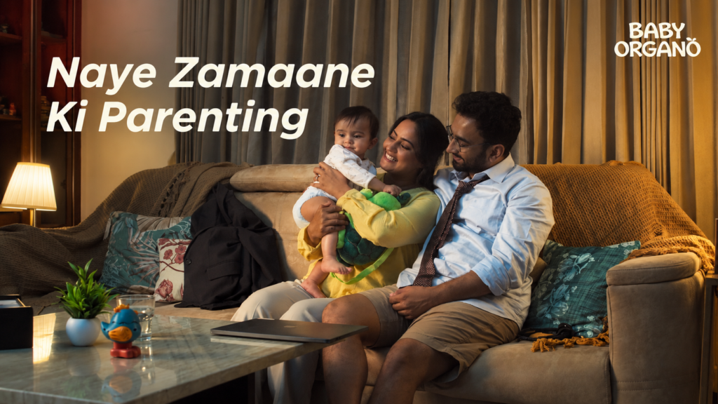 BabyOrgano parenting campaign showing a couple playing with a baby on a sofa.