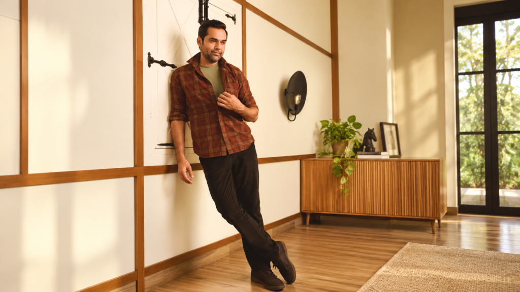 ColorPlus fashion campaign featuring a man leaning against a wall in a sunlit home.