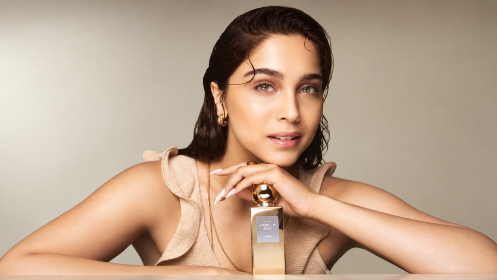 H&M Beauty campaign portrait of a woman holding a perfume bottle.